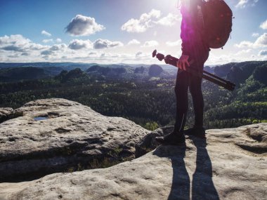 Yaratıcısı ve fotoğrafçı kaya üzerinde duran için tripod kuruyor