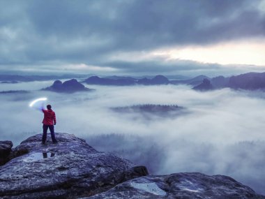 Karanlığın içine keskin ışık sinyalleri gönderen kadın.