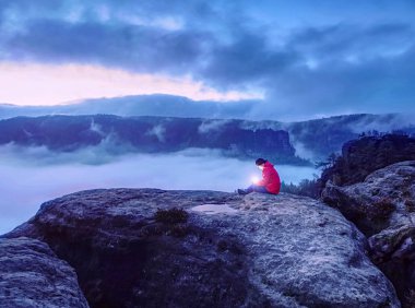 Kayıp kadın, dağın zirvesinde el ele tutuşup parlayan lambayı tutuyor.
