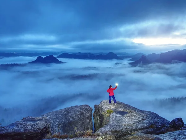 Verlorene Frau hält in Händen leuchtende Lampe auf Berggipfel — Stockfoto