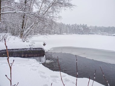 Kış gölü kıyısı. Kanal altında buzda açık su var.