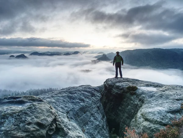 Caminhada nas montanhas do outono. Homem ficar acima névoa pesada no vale — Fotografia de Stock