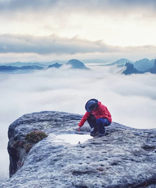 Hiker girl on mountain summit soak leaf in water eye pool — Stock Photo, Image