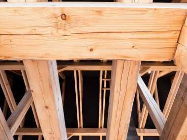 Ahşap kirişler ve alçak açılı manzaralı çatı inşaatı. Büyük ladin kütükleri, kirişler, kirişler.