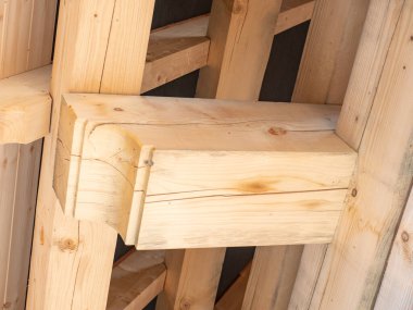 Ahşap kirişler ve alçak açılı manzaralı çatı inşaatı. Büyük ladin kütükleri, kirişler, kirişler.