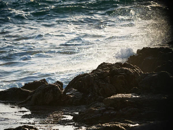 Sea Wave Slår Klippen Mod Solnedgangen Vandspray - Stock-foto