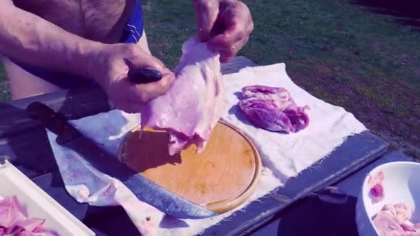 나이프가 도마에 돼지고기 고기를 넣었습니다 셰프가 잔디를 배경으로 깨끗하고 도려낸 — 비디오