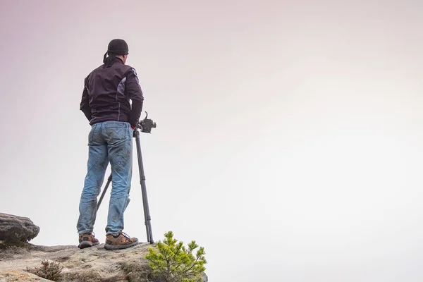 stock image Silhouette of a professional photographer using a tripod, taking a photo of a mountain landscape