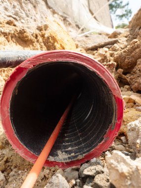 Tırtıklı, esnek kırmızı plastik tüp içinde optik fiber kablo ayrıntıları, lamba direğinde ince siper 