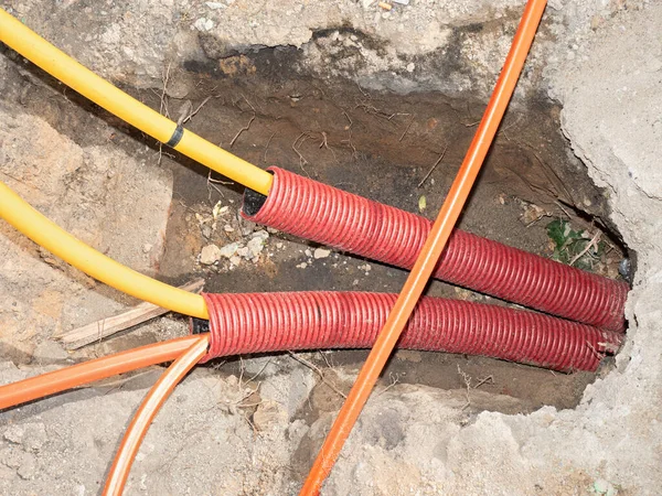 Elektrik kabloları olan bir inşaat siperi. Telekom için fiber optik kabloların kurulumu için yol çalışması.