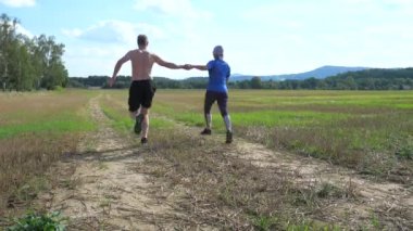 Tanımlanamayan heteroseksüel çiftlerin bacakları kameranın üzerinden atlıyor ve renkli sonbahar doğasında koşuyor. Görüntüyü kapat .