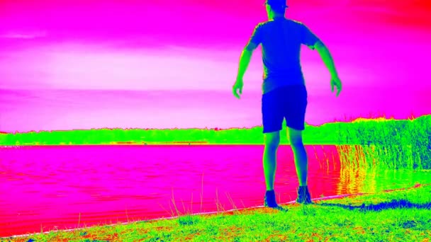 サーモビジョン画面で大人のスポーツマンを実行してストレッチ 自然放出を加熱し 男性の体を暖める 砂浜のある湖湾 — ストック動画