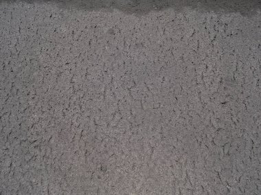 Yüzey asfalt pürüzlü, eskimiş asfalt, koyu gri kumlu yol. Doku arkaplanı