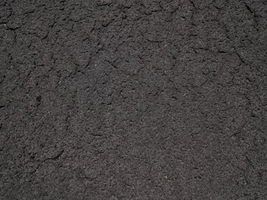 Eski asfalt hırıltısı, yıpranmış asfalt, koyu gri kumlu yol. Doku arkaplanı