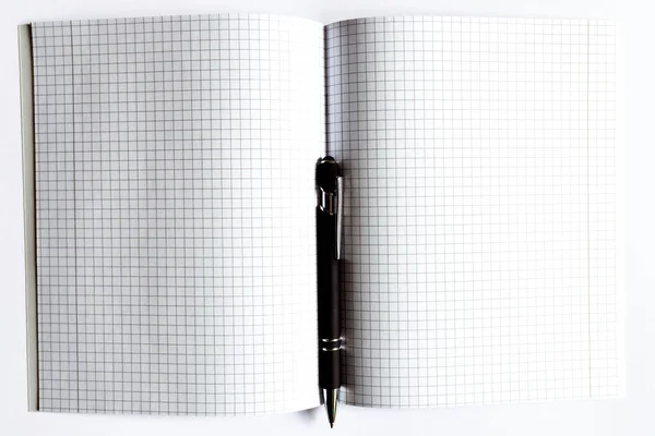 Top view Checkered notebook with a black pen on a white background. Place for text.Copy space.Banner advertisement.