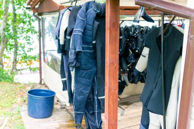 Plateliai Litvanya 08 24 2020 Neprene dalış giysileri kurumak için dışarıda asılı. Tüplü dalış merkezinde birden fazla asılı dalgıç kıyafeti..