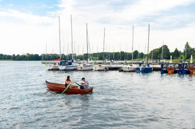 Plateliai Litvanya 08: 24 2020 Genç çift küçük kırmızı bir teknede oturuyor ve eğleniyorlar..