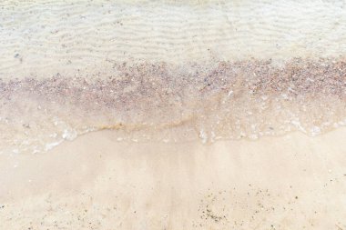 Üst manzara Kumlu sahilde beyaz köpükle denizin yumuşak dalgası. Boşluğu kopyala