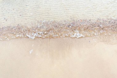 Üst manzara Kumlu sahilde beyaz köpükle denizin yumuşak dalgası. Boşluğu kopyala