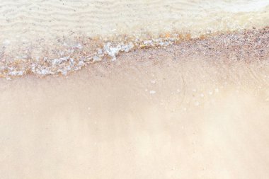 Üst manzara Kumlu sahilde beyaz köpükle denizin yumuşak dalgası. Boşluğu kopyala