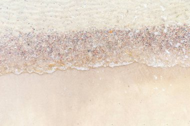 Üst manzara Kumlu sahilde beyaz köpükle denizin yumuşak dalgası. Boşluğu kopyala