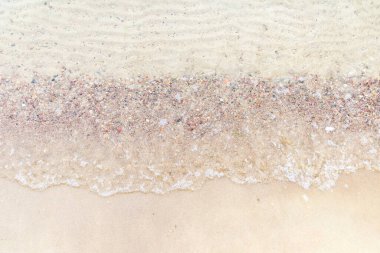 Üst manzara Kumlu sahilde beyaz köpükle denizin yumuşak dalgası. Boşluğu kopyala