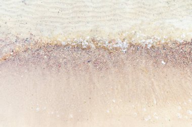 Üst manzara Kumlu sahilde beyaz köpükle denizin yumuşak dalgası. Boşluğu kopyala