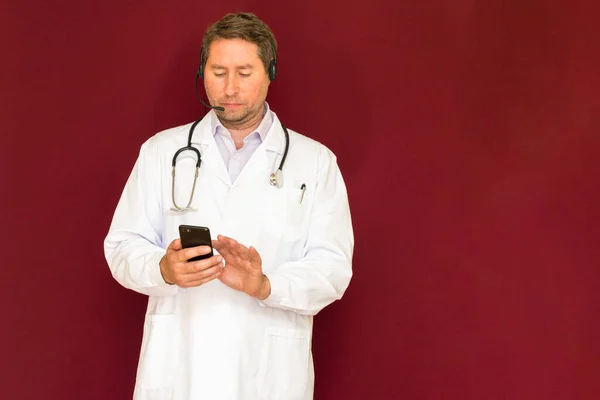 Young Caucasian Doctor Stethoscope Talking Patient Online Red Studio Background — Stock Photo, Image