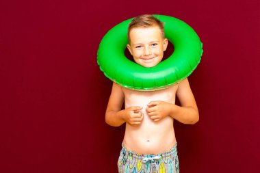 Yaz tatili konsepti, mutlu beyaz çocuk portresi çıplak çocuk şortu sırılsıklam mayo çocuk yaz tatilinde eğleniyor, stüdyo çekimi kırmızı arka plan.