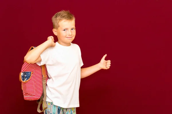 Счастливый Веселый Школьник Рюкзаке Большими Пальцами Красной Стене Студии — стоковое фото