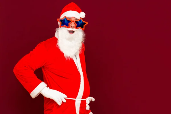 Portrait Von Positiven Jungen Weihnachtsmann Blick Auf Kamera Roten Studiohintergrund — Stockfoto