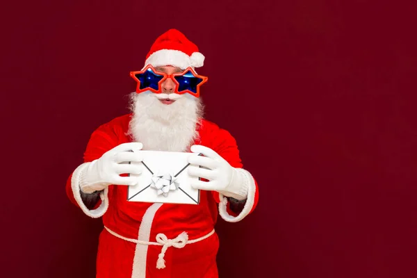 送礼服务 戴假胡子的圣诞老人戴着圣诞礼帽 手里拿着礼品盒 圣诞节或新年假期 男人的圣诞礼品盒 圣诞佳节男人带着礼物 — 图库照片
