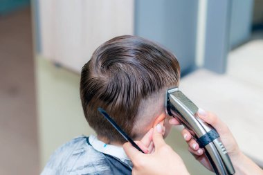 Kafkas asıllı Amerikalı güzel öğrencinin yakın çekimleri modern berber dükkanında saç makasıyla son moda bir saç kesimi vardı..