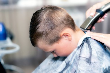 Kafkas asıllı Amerikalı güzel öğrencinin yakın çekimleri modern berber dükkanında saç makasıyla son moda bir saç kesimi vardı..