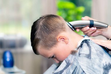 Kafkas asıllı Amerikalı güzel öğrencinin yakın çekimleri modern berber dükkanında saç makasıyla son moda bir saç kesimi vardı..