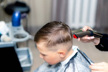 Kafkas asıllı Amerikalı güzel öğrencinin yakın çekimleri modern berber dükkanında saç makasıyla son moda bir saç kesimi vardı..