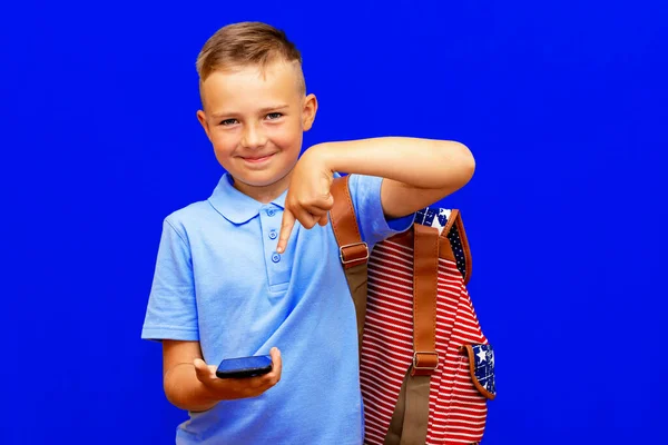 Lächelnder Schuljunge Legerer Kleidung Rucksack Isoliert Auf Hellblauem Hintergrund Zeigefinger — Stockfoto
