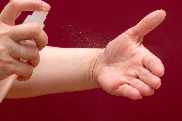 Kézben Tartva Fertőtlenítő Antibakteriális Fertőtlenítő Spray Tenyérbe Burgundi Háttérrel Elszigetelve — Stock Fotó