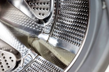 Modern kirli ya da temiz çamaşır makinesinin iç kapakları açık olan detaylarını kapatın. Gümüş renkli, paslanmaz davul, tasarım ve teknoloji.