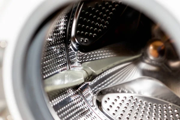 Close up detail of modern dirty or clean washing machine interior with open door interior. Silver shiny stainless drum, design and technology.