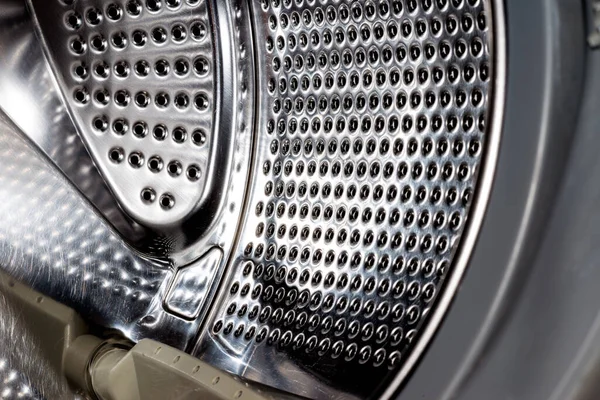 Close up detail of modern dirty or clean washing machine interior with open door interior. Silver shiny stainless drum, design and technology.