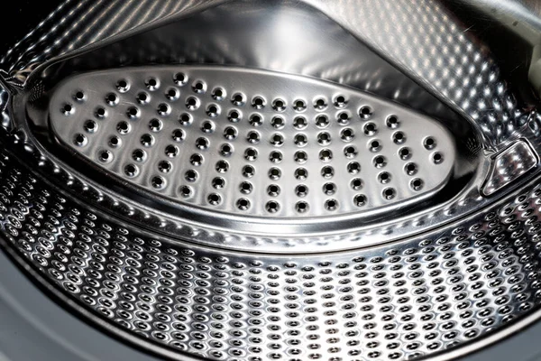 Close up detail of modern dirty or clean washing machine interior with open door interior. Silver shiny stainless drum, design and technology.