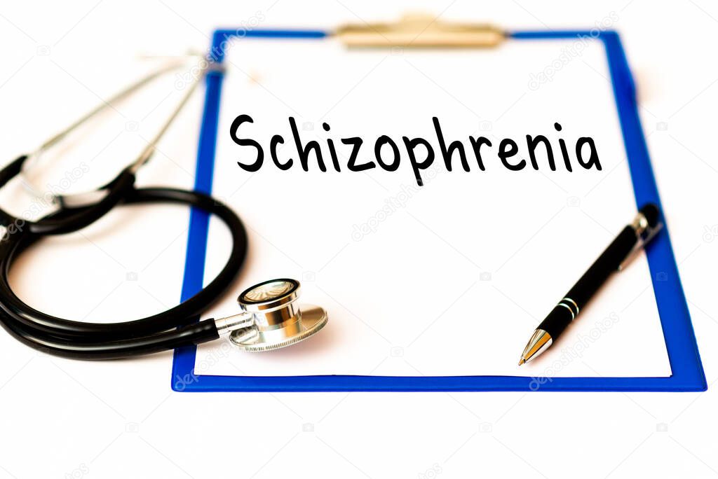 SCHIZOPHRENIA and psychotic concept schizophrenia tex on a doctor's paper holder next to a pen stethoscope.Mental or schizophrenia treatment