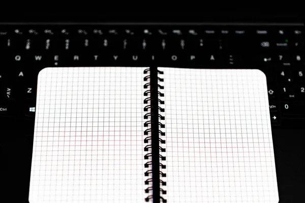 最小限の作業スペース ペンのない空白のノートブックはノートパソコンのキーボードにあります — ストック写真