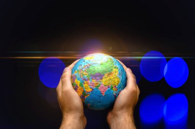 Dünya Gezegeni, insanların elinde renkli lambalara karşı bulanık. İş, politika, ekoloji ve medya kavramları. Dünya gecesi soyut arkaplanı.