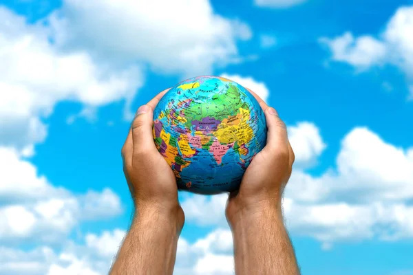 Lidské Ruce Drží Malý Svět Zeměkoule Země Rozmazané Modré Obloze — Stock fotografie