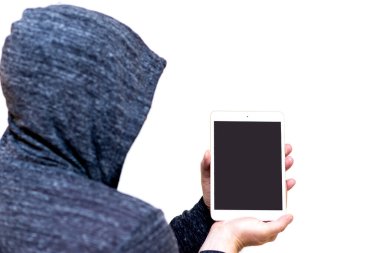 Gri sweatshirt kapüşonlu adam beyaz stüdyo arka planında izole edilmiş kopyalama alanı için boş ekranlı tablet bilgisayar tutuyor..