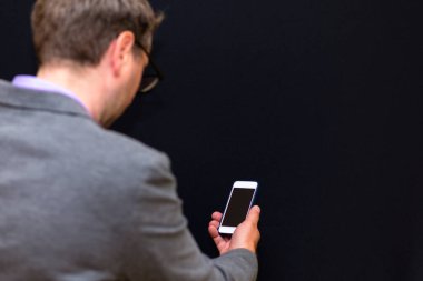 Yan görünüm, yakın plan İşadamı Akıllı Telefon, tecrit edilmiş Siyah Stüdyo Arkaplan Kullan