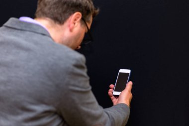 Yan görünüm, yakın plan İşadamı Akıllı Telefon, tecrit edilmiş Siyah Stüdyo Arkaplan Kullan