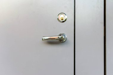 Dış kapı kolu ve güvenlik kilidi açık gri metal çerçeve üzerinde